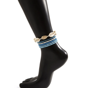 Detail van de bohemian bodychain met natuurlijke schelpen en blauwe kralenlagen