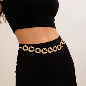 Detail of gold textured rings on a layered body chain worn over black clothing