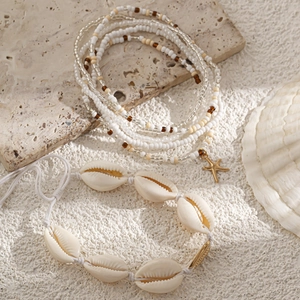 Detail van bohemien schelpen kralen taille ketting met gouden zeester op steen