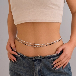 Detailed view of a double-layered body chain with black and white beads and seashell charms