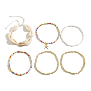 Detailopname van bohemien meerstrengs armbandenset met kauri schelp en zeester hanger
