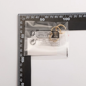 Golden irregular ring set in transparent packaging with measurement scale detail
