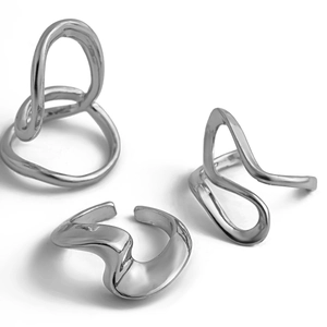 Detail of three liquid lava silver rings featuring irregular wavy and hollow designs