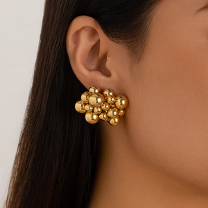 Close-up of chunky gold cluster stud earrings featuring a bold metallic bead design