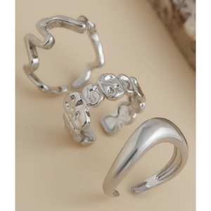Detailed view of silver irregular lava texture and polished open ring set on beige background