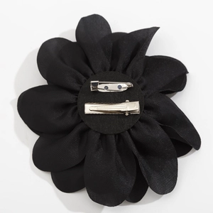 Schwarze Stoffblumen-Brosche mit kombiniertem Haarclip und Sicherheitsnadel auf Weiß