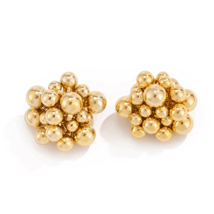 Close-up of golden geometric bead cluster earrings with polished metallic finish