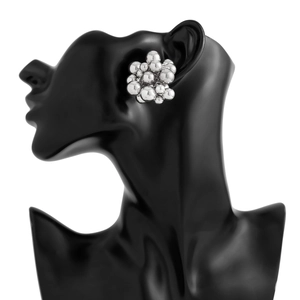 Detailed view of silver-tone clustered bead earrings on a black mannequin display