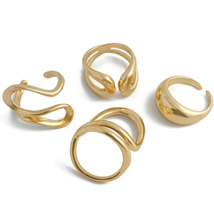 Detailed view of four modern liquid lava gold rings with polished metallic finish