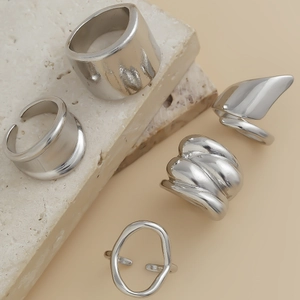 Macro detail of 5-piece silver irregular geometric rings with polished lava texture