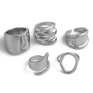 Detail view of five silver irregular metal rings set with minimalist abstract design
