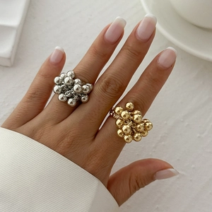 Detailaufnahme von klobigen Perlenclustern-Ringen in Gold und Silber am Finger