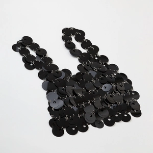 Dettaglio del design della maglia di paillettes nere su una borsa a mano moderna