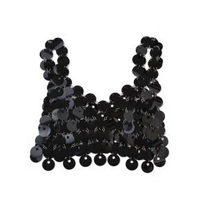 Dettaglio del top crop con paillettes nere che mostra anelli metallici e maglie