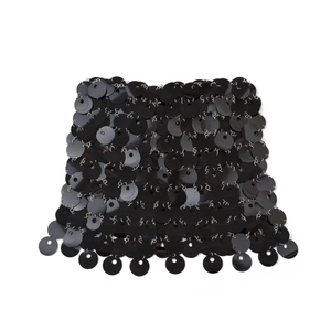 Dettaglio delle paillettes nere e degli anelli metallici argento sulla catena per il corpo
