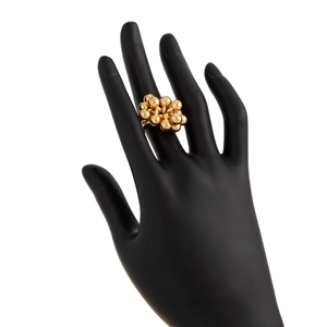 Detail of a gold bead cluster ring with a grape-like sphere design on a black mannequin hand