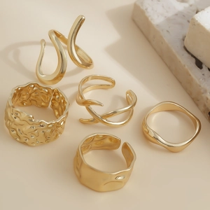 Macro view of five-piece gold irregular molten rings set with hammered and wavy textures