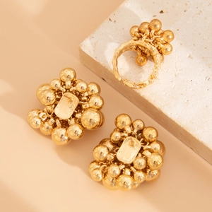 Detailed close-up of golden beaded earring and adjustable textured lava ring set