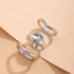 Detailansicht eines silbernen Ringsets mit glatten Kuppel- und Wellenformen