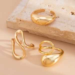 Detailed view of three-piece liquid lava gold-plated open rings on a stone surface