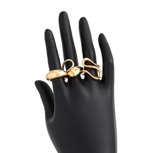 Detailed view of three gold liquid lava rings displayed on a black hand model