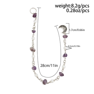 Dettaglio di gioielli boho per capelli con pietre naturali viola e ciondoli luna e stelle