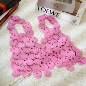 Dettaglio della catena per il corpo con paillettes rosa e scaglie circolari luccicanti