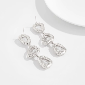 Vue détaillée des boucles d'oreilles pendantes en métal martelé argenté style rétro