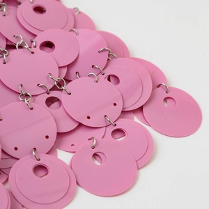 Dettaglio ravvicinato della catena bikini con paillettes rosa e anelli in metallo argento