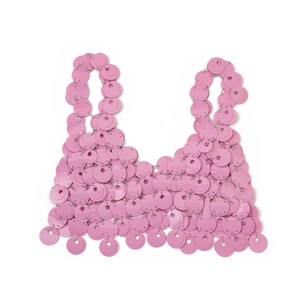 Dettaglio del crop top con paillettes rosa e struttura a dischi metallici a strati