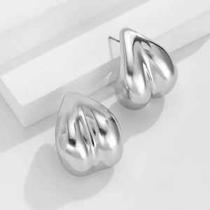 Détail de boucles d'oreilles irrégulières en forme de goutte au fini poli miroir