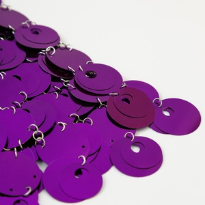 Dettagli macro di paillettes viola con anelli in argento su catena per il corpo