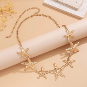 Detailed view of a gold starfish body chain featuring seven textured metal pendants