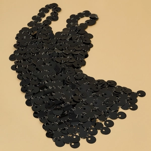 Dettaglio della catena per il corpo con paillettes nere e anelli in metallo a scaglie