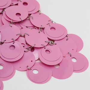 Dettaglio di paillettes rosa tonde con anelli d'argento su una catena per il corpo