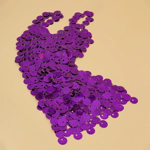 Dettaglio macro della catena corpo con paillettes viola scuro e trama metallica