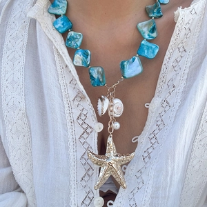 Dettaglio della collana stile oceano con perle marmorizzate blu e ciondolo a stella marina