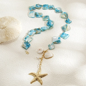 Dettaglio della collana stile oceano con ciondolo a stella marina, conchiglie e perla