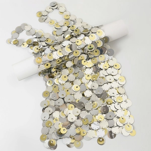 Dettaglio di paillettes metalliche oro e argento su una catena per il corpo bikini