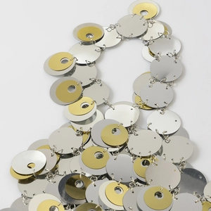 Dettaglio di paillettes metalliche argento e oro collegate su una catena per corpo da spiaggia