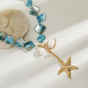 Dettaglio ravvicinato della collana a tema oceano con stella marina dorata e ciondolo