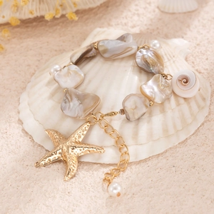 Dettaglio della collana di conchiglie stile marino con stella marina dorata e perla