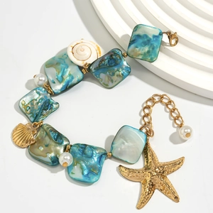 Dettaglio collana marina con scaglie di conchiglia blu, stelle marine e perle su sfondo bianco