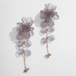 Détails de boucles d'oreilles florales avec pétales irisés et accents en métal doré