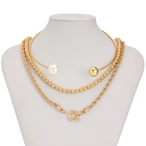 Detailed view of layered gold necklace featuring twisted rope chain and large spring clasp