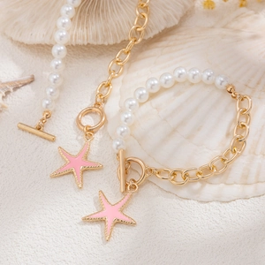 Dettaglio della collana con stella marina, perle e chiusura a levetta dorata stile nautico