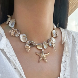 Dettaglio della collana stile oceano con ciondoli a stella marina, tartaruga e cavalluccio