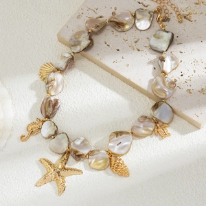 Dettaglio della collana stile oceano con perle di conchiglia e ciondoli marini dorati