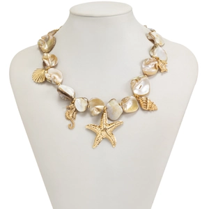 Dettaglio della collana in conchiglia con ciondoli dorati a forma di stella e cavalluccio