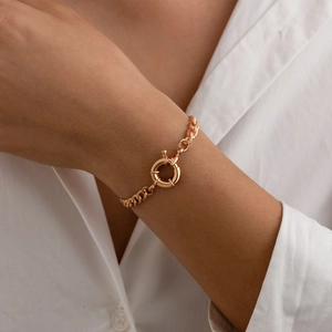 Detail of chunky gold snake chain necklace with large round spring clasp on a model